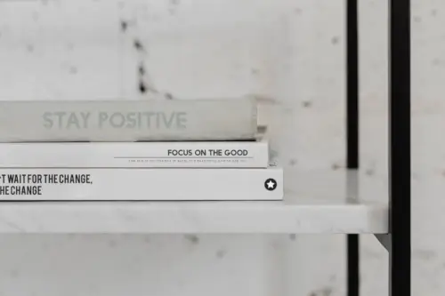 A stack of psychology books rests on a white marble shelf.