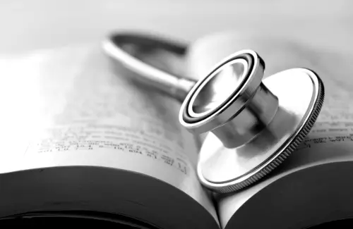 A stethoscope and a book on a table.