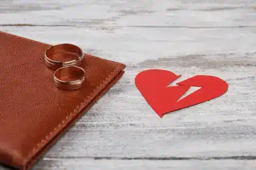 Close-up broken heart and wedding rings.